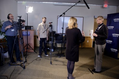 From left, videographers Frank Barton and Ethan Giorgetti interview UConn Health employee Jean Menze. (Photo by Janine Gelineau)
