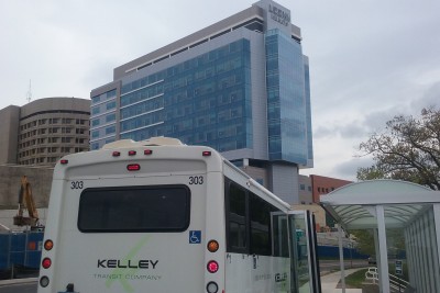 A shuttle bus in the shadow of the new UConn Health John Dempsey Hospital tower. (Photo by Chris DeFrancesco)